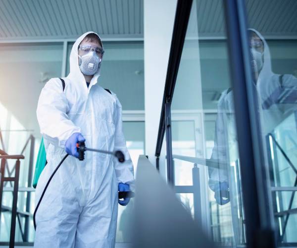 Professional industrial cleaners using equipment in warehouse facility